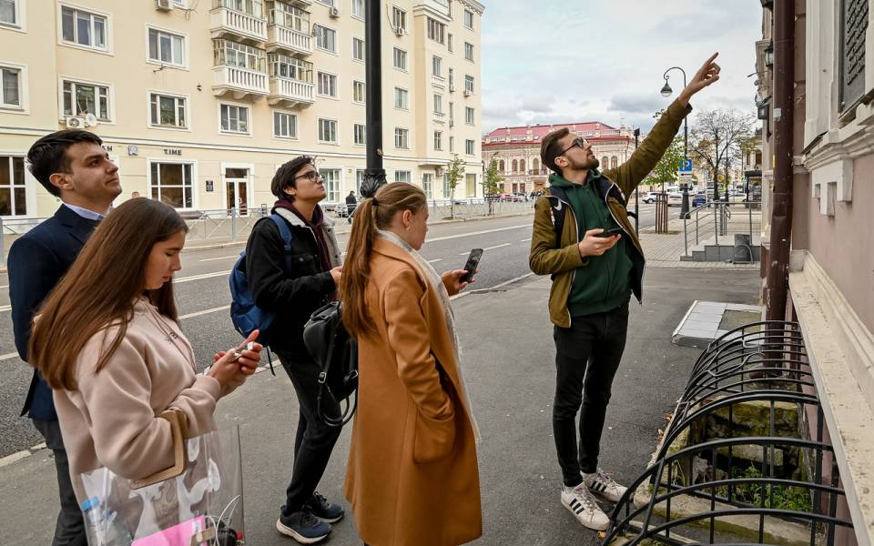 Участник команды ФСПО указывает на&nbsp;памятное здание Казани